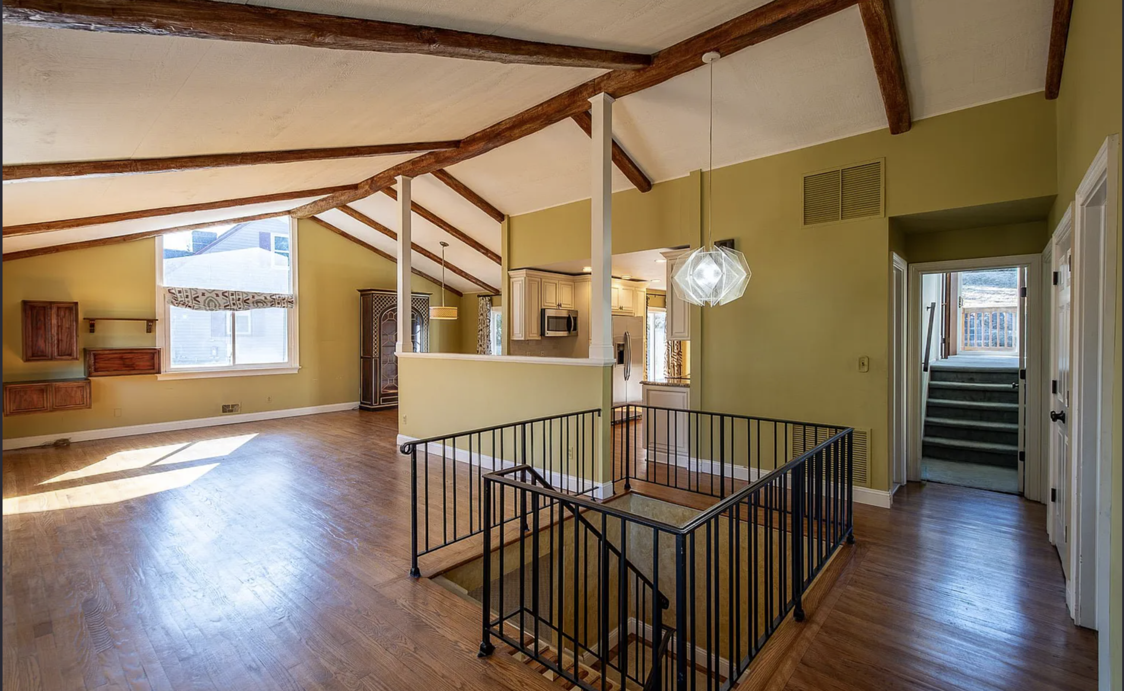 Empty great room with olive walls — before virtual staging