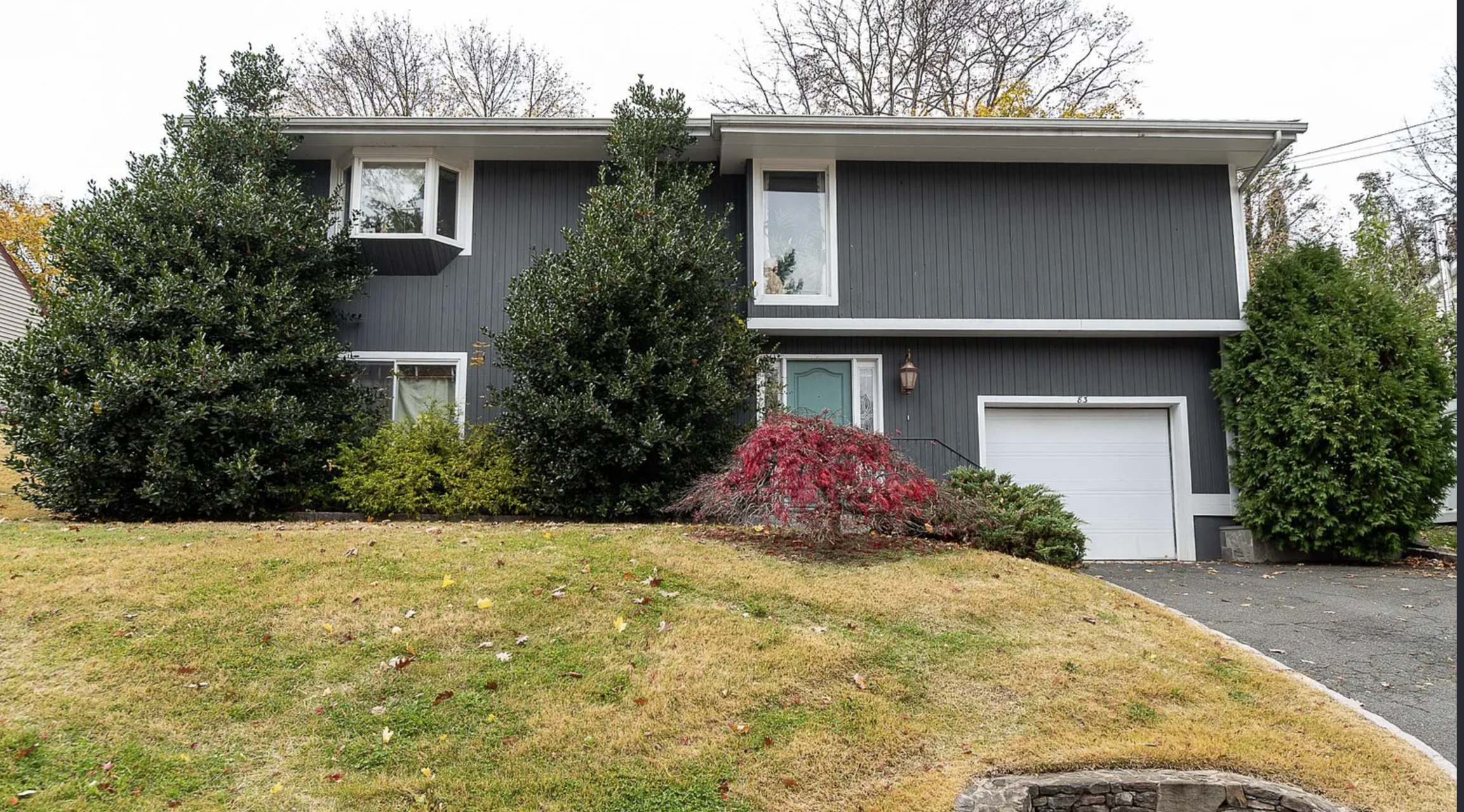 Home exterior before virtual staging with bare landscaping
