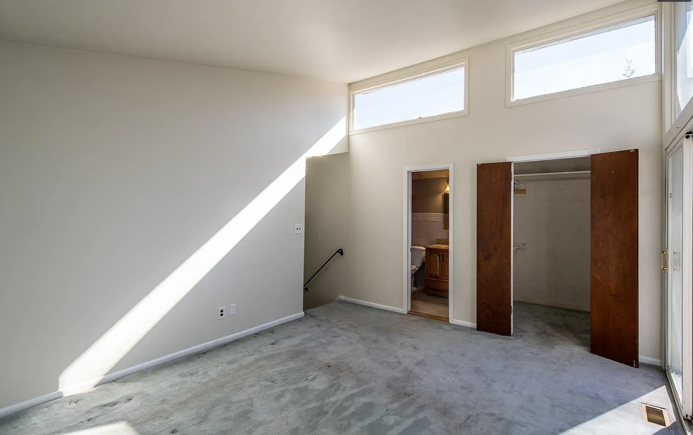 Empty bedroom with worn carpet before virtual staging